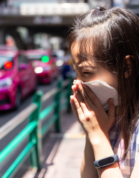 Little girl covering her face with a tissue