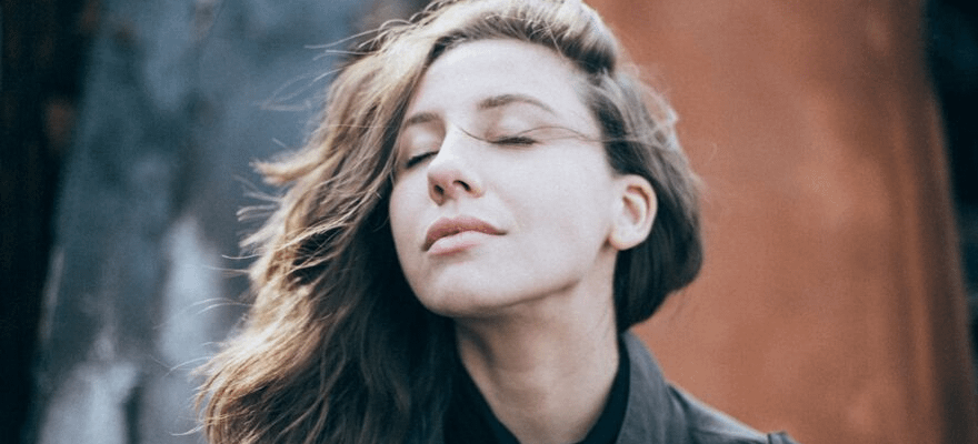 Brunette woman with her eyes closed hair in the wind