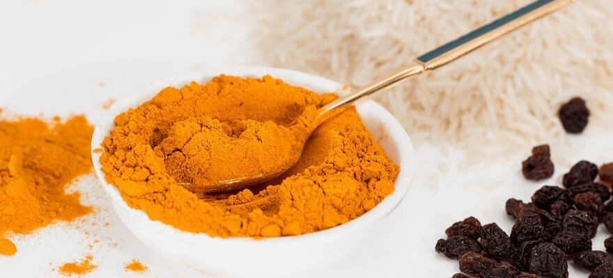 Close up of a white bowl filled with turmeric