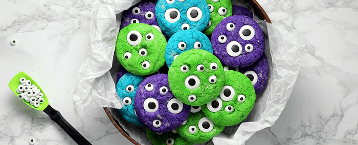 spooky halloween cookies in blue, green, and purple with googly eyes