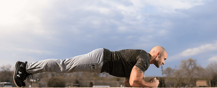Fit male outdoors holding a plank position