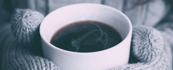A steaming cup and black coffee in a white mug