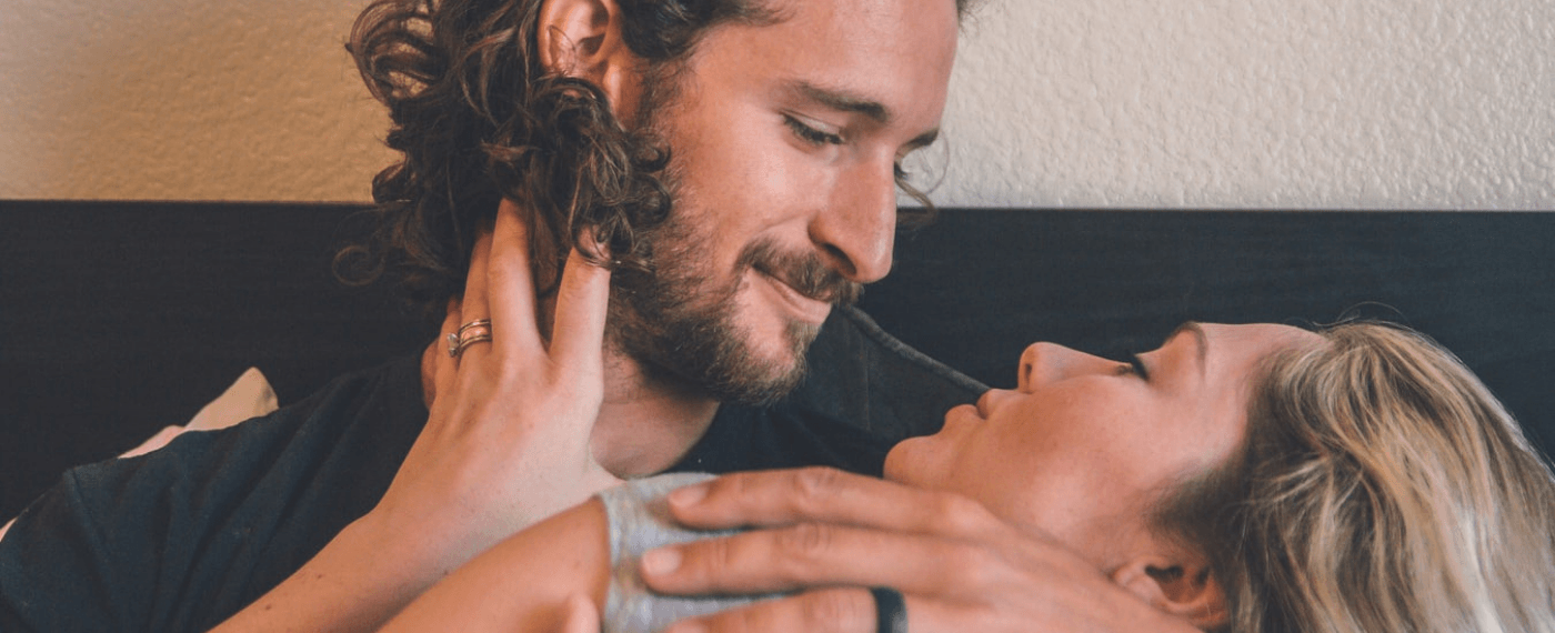 man and woman holding each other smiling discussing sex positions for getting pregnant