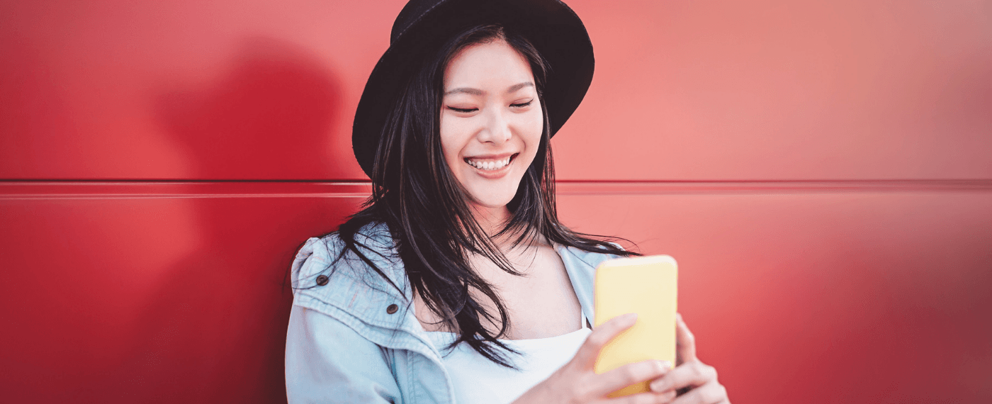 girl smiling while looking at smartphone