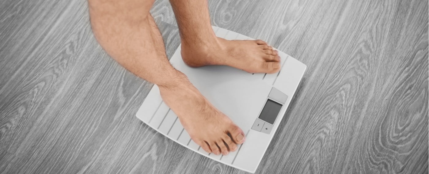 man on scale weighing himself