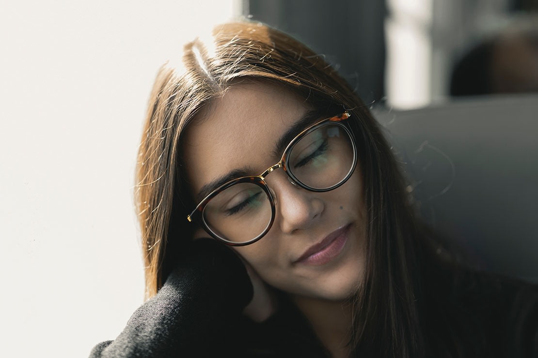 Woman with glasses enjoying resting her head on her hand