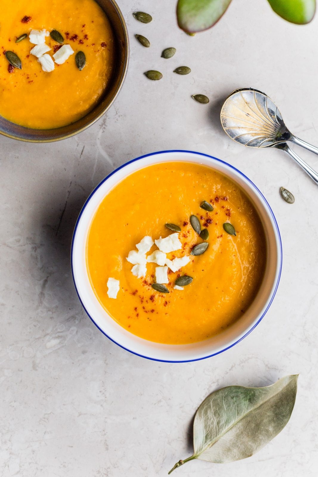 A bowl of pumpkin soup with roasted pumpkin seeds on top