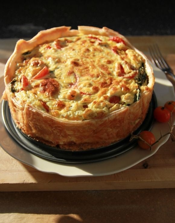 Reheated pizza quiche with fresh cherry tomatoes on the side