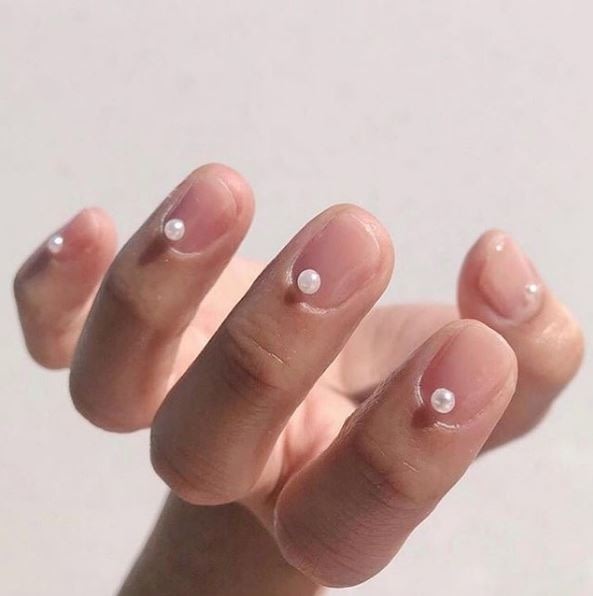 A single small pearl glued to each manicured nail