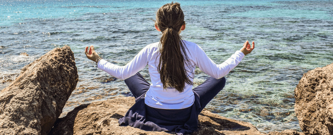 Woman meditating by the beach