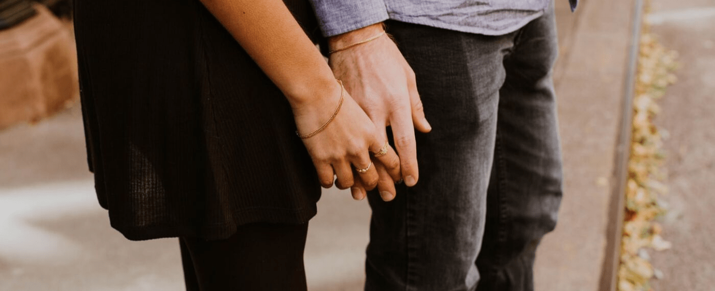 woman taking hold of man's hand