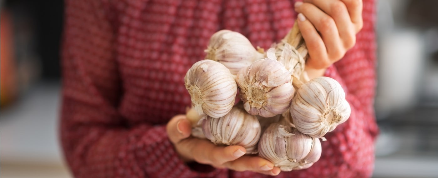 woman holding a bundle of garlic cloves good for blood pressure