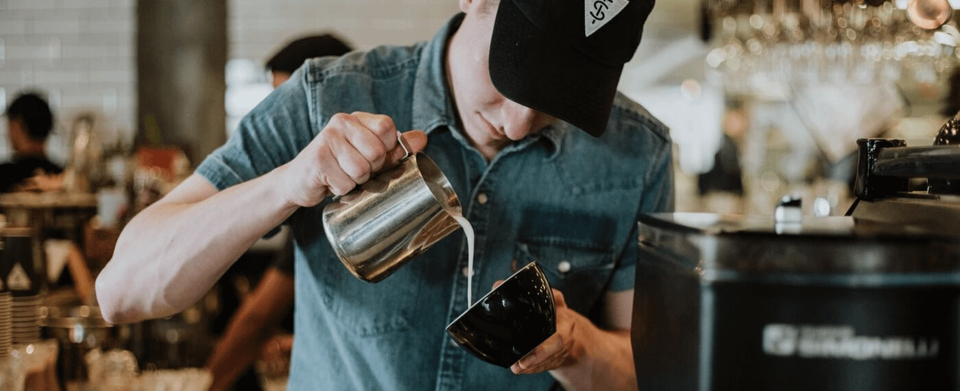 Man making a latte in a coffee shop