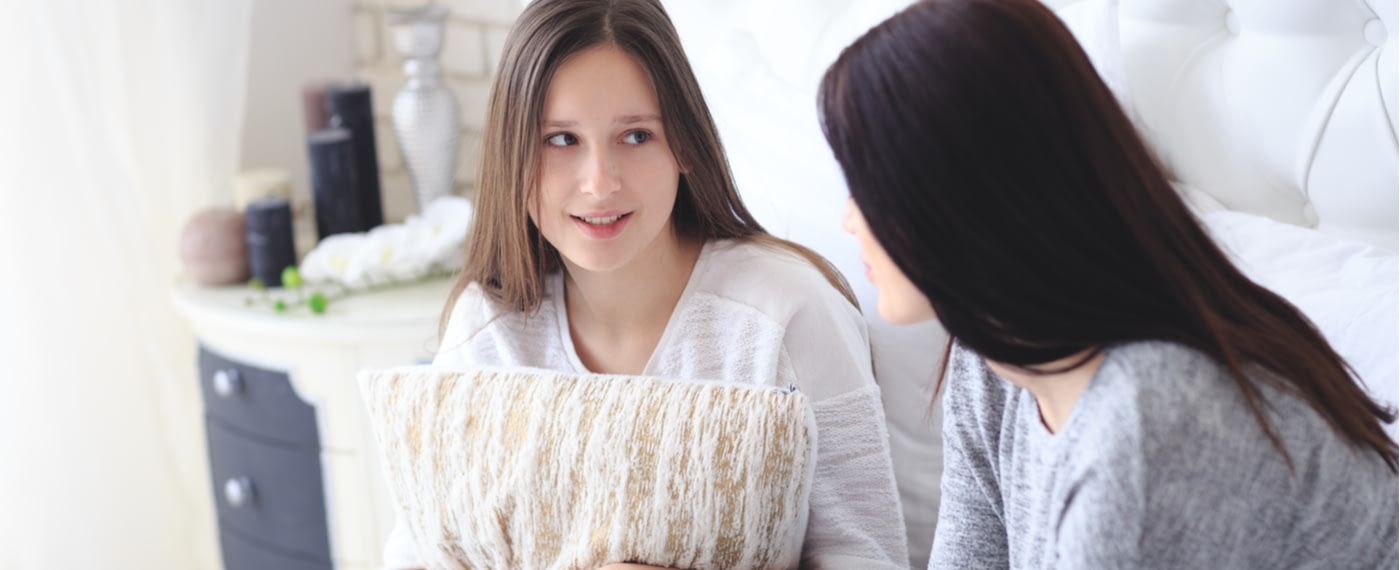 Mother talking to embarrassed teenage daughter