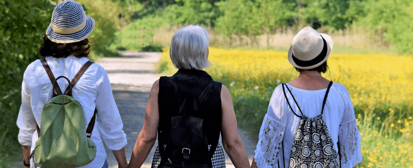 Three woman with perimenopause holding hands and walking