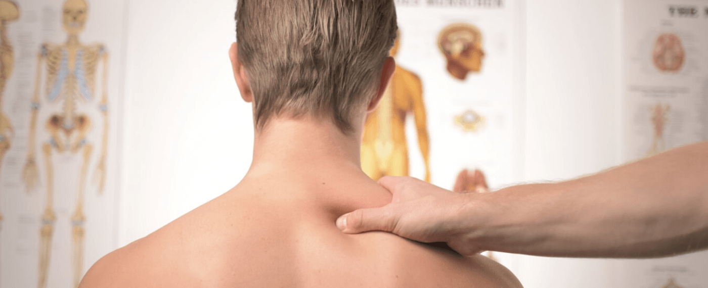 man getting his shoulder massaged by physician