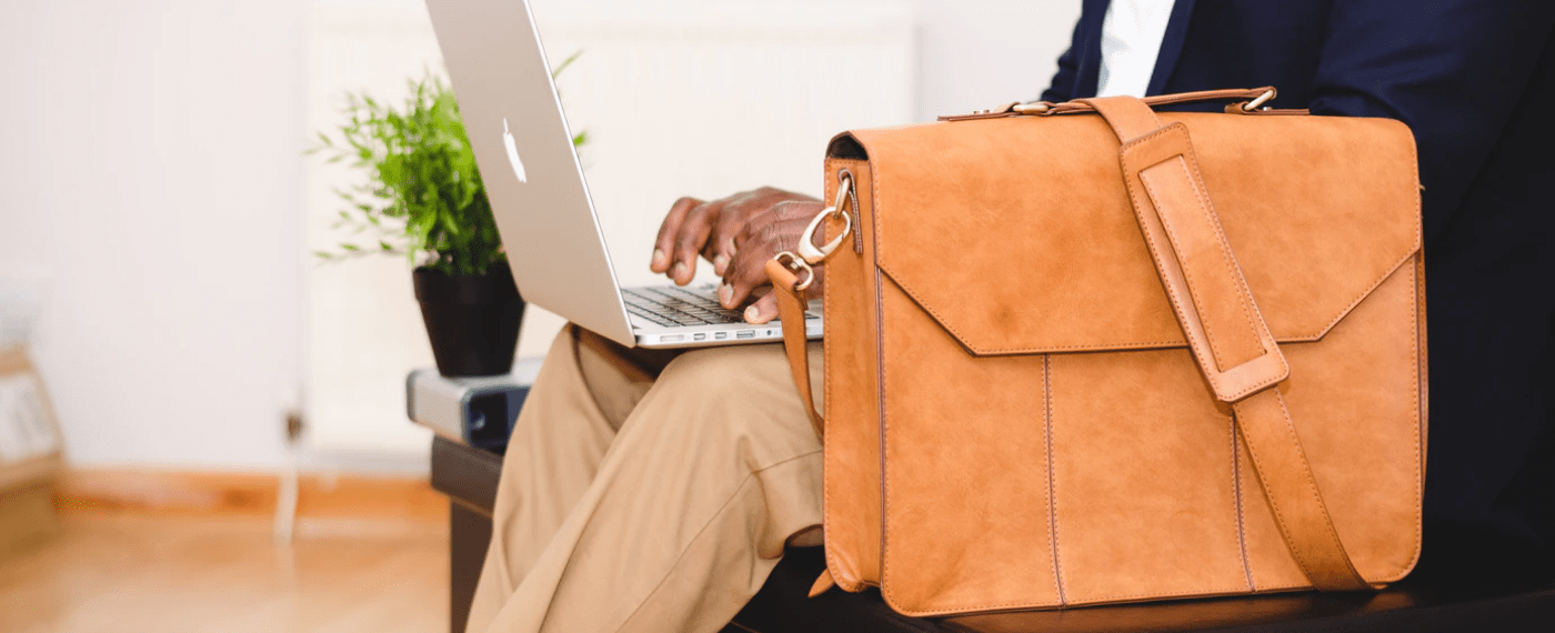 Man with suitcase and laptop working in a waiting room due to poor time management