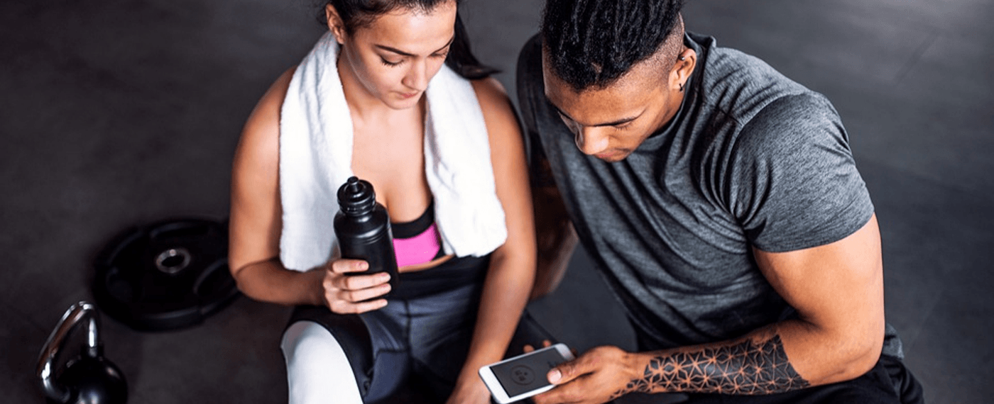 fit couple using smart phone app to help motivate workout