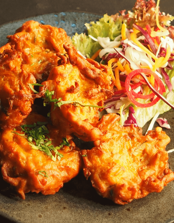 A plate of fried shrimp next to a salad