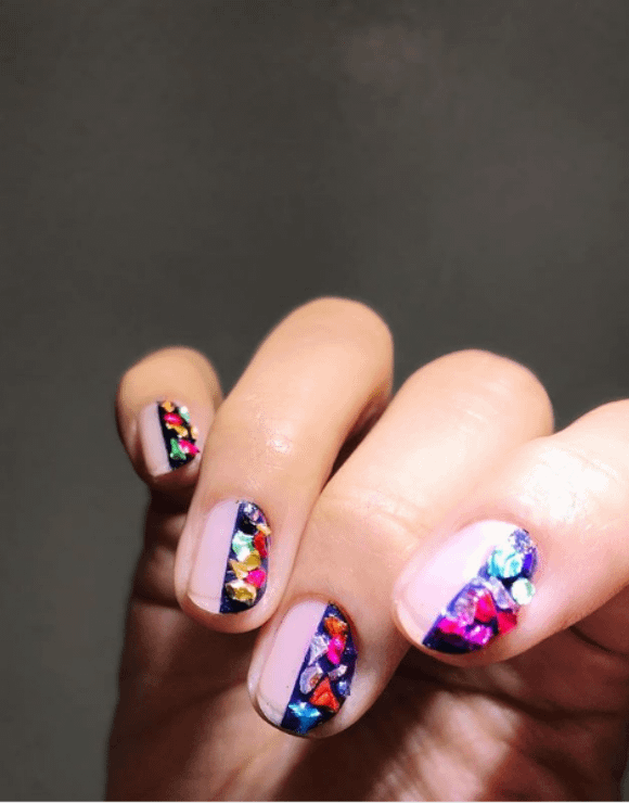 Manicured nails showing nail polish with colorful gems