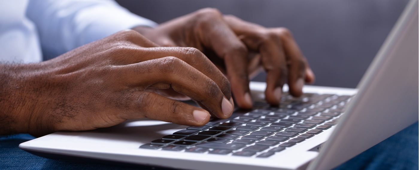 Man typing on laptop keyboard