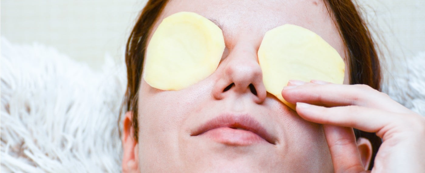woman using potato slices to help with baggy eyes
