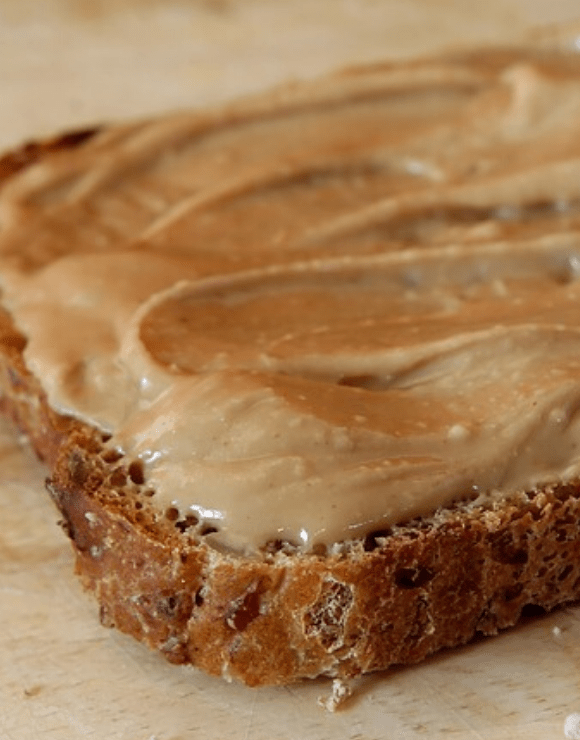Healthy peanut butter spread across a piece of toast