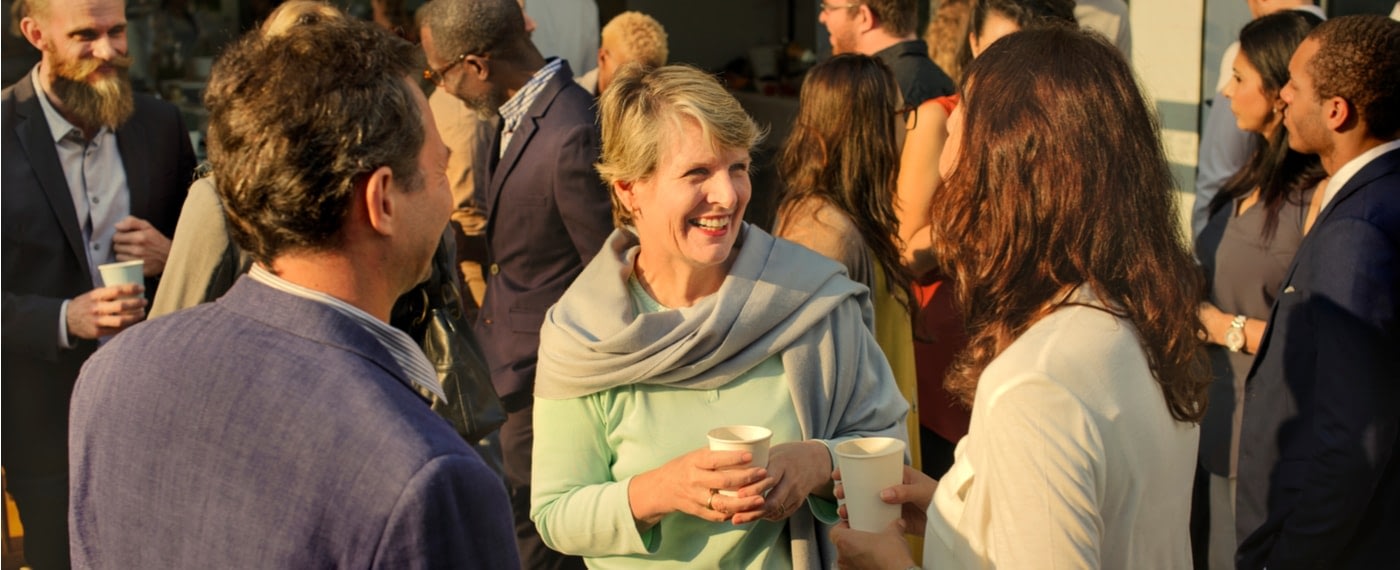 older woman speaking with guests at a house party