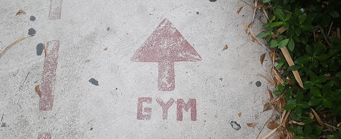 Directions to the gym painted on a sidewalk