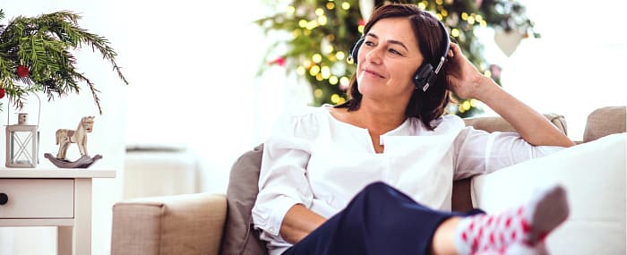 woman sitting outside enjoying music through headphones
