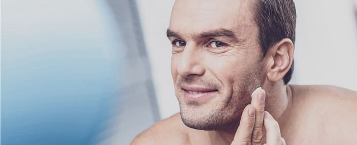 Man applying moisturizer to face to relieve dry skin