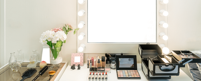 Brightly lit makeup vanity mirror with makeup products spread out
