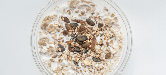 A bowl of oats and milk that help improve gut health reducing bile acids & lowering cholesterol