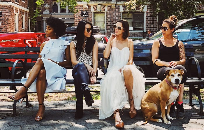 group of four females with one dog chatting about self care staycation