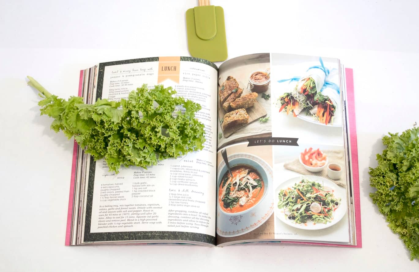 healthy recipe book open with kale resting on the cover