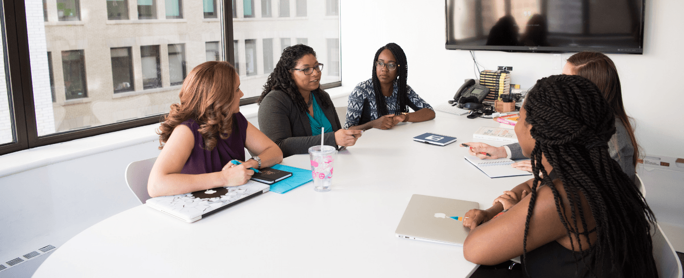 group of business women discussing the importance of employee motivation in an office