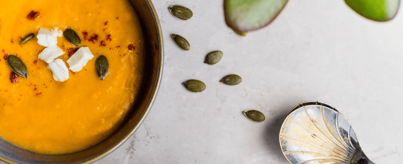 a bowl of squash soup with pumpkin seeds for eating healthy at restaurants