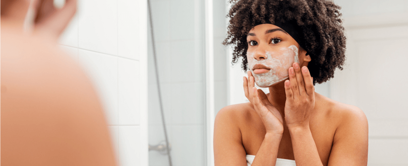 a young woman practicing self care through a skincare routine