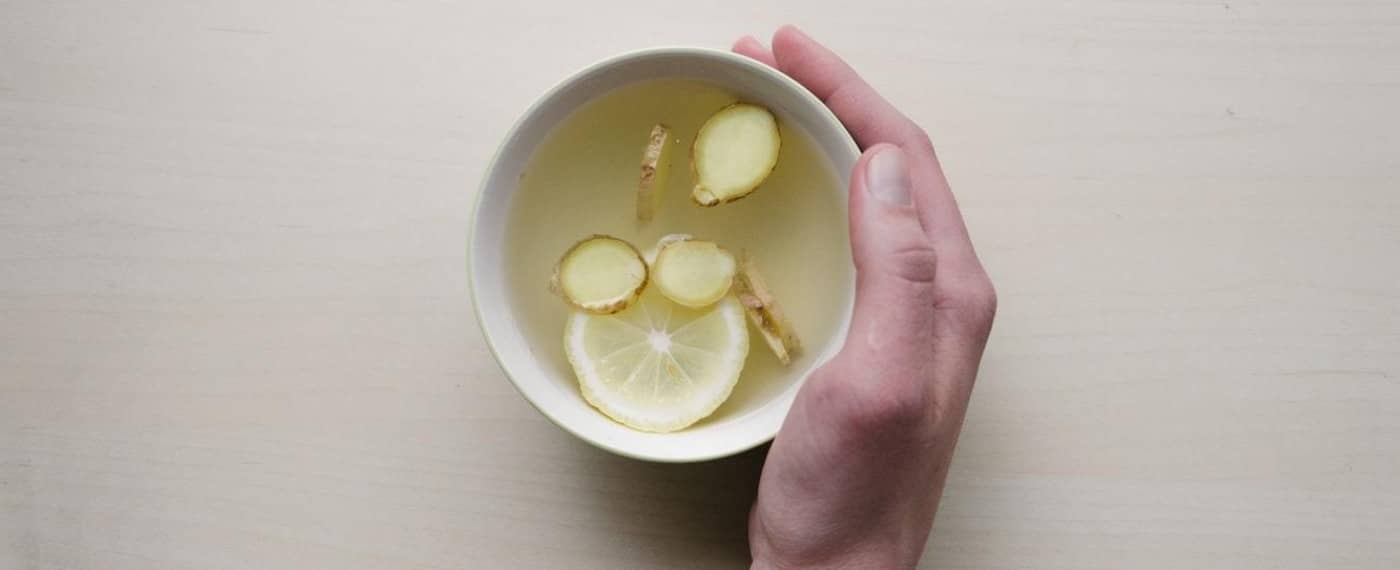 a cup of broth with ginger and lemon