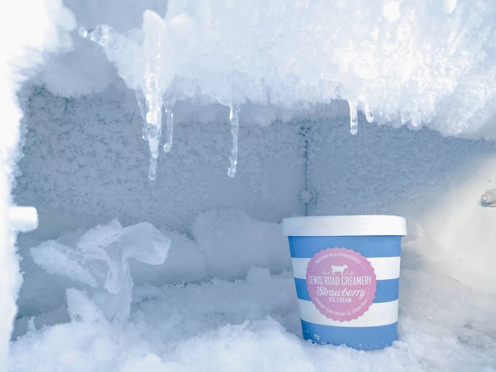 The frozen ice inside a freezer with a quart of strawberry ice cream