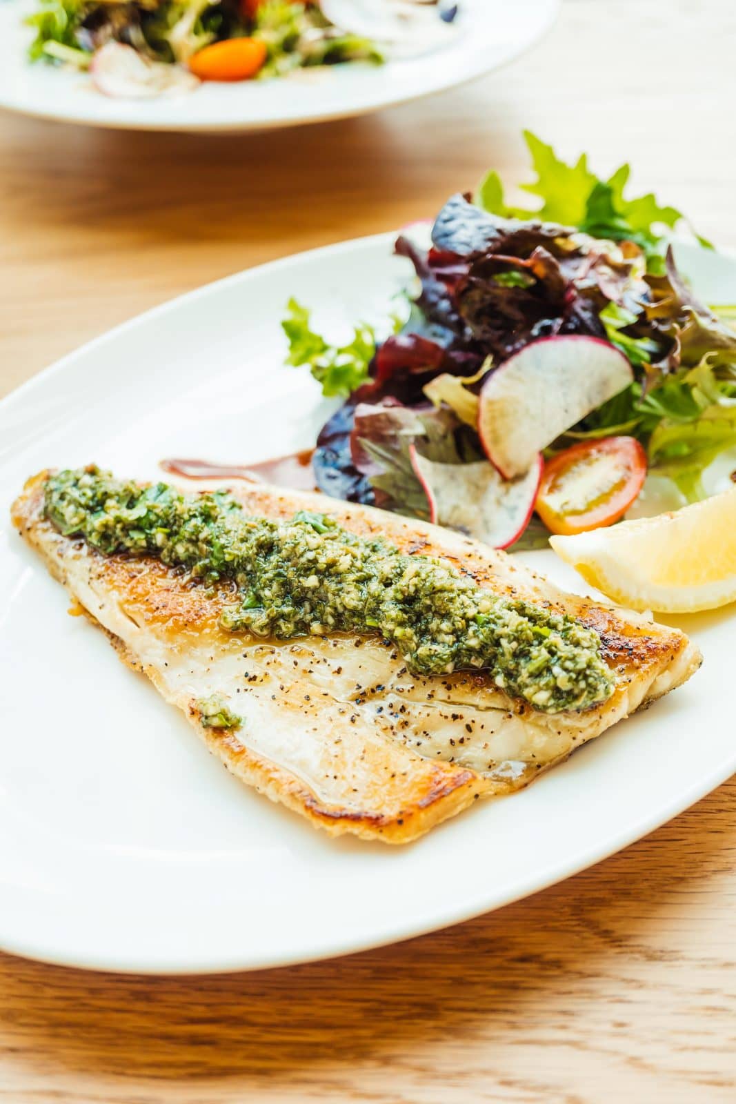 Grilled fish with pesto sauce with a side of vegetables