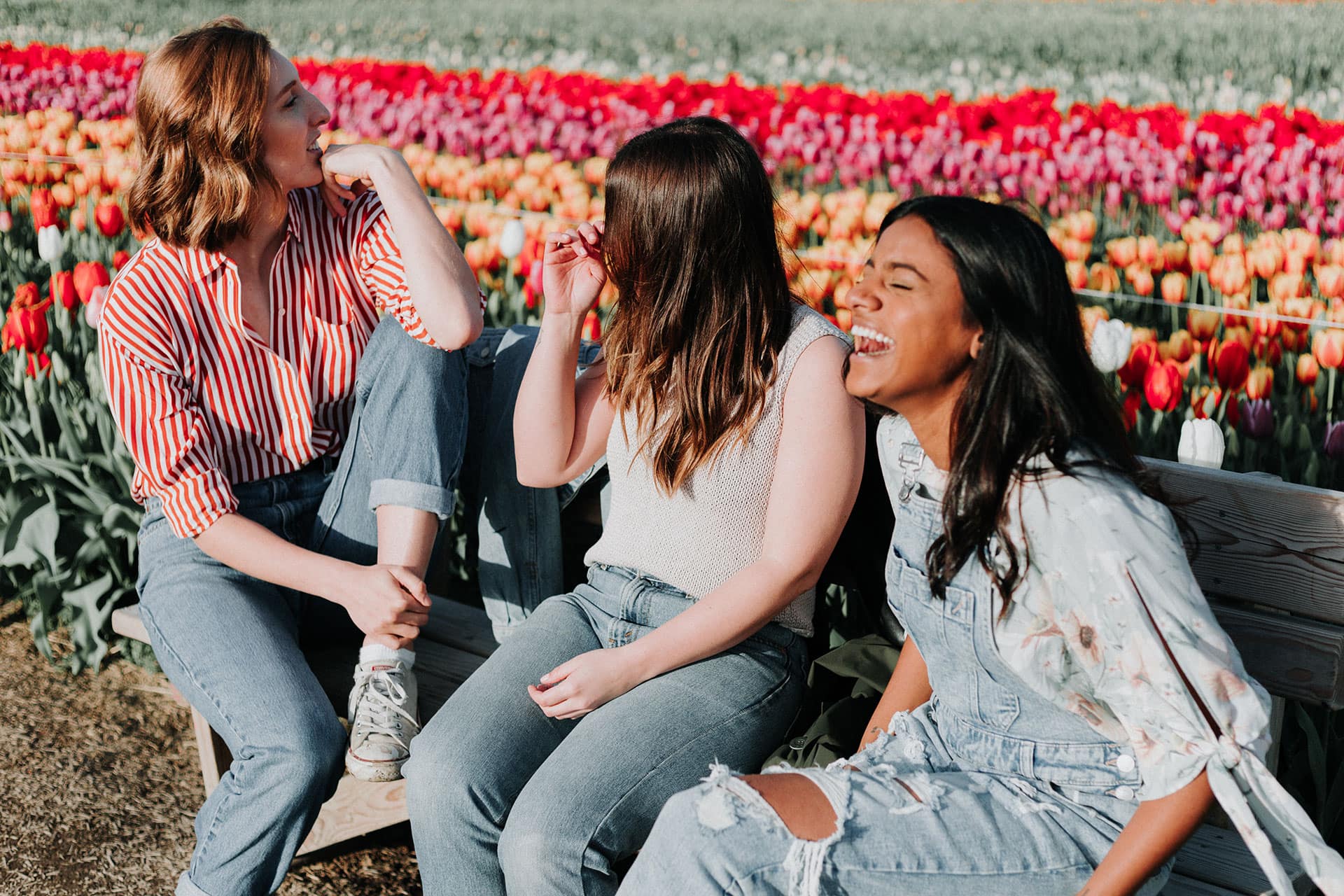 group of female friends laughing over self care quiz results