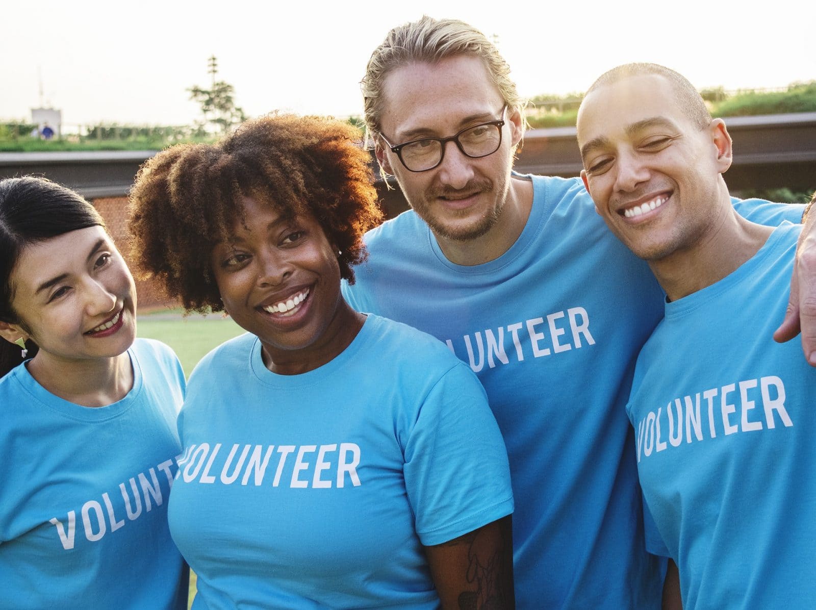 Two men and two women wearing volunteer's t shirts smiling