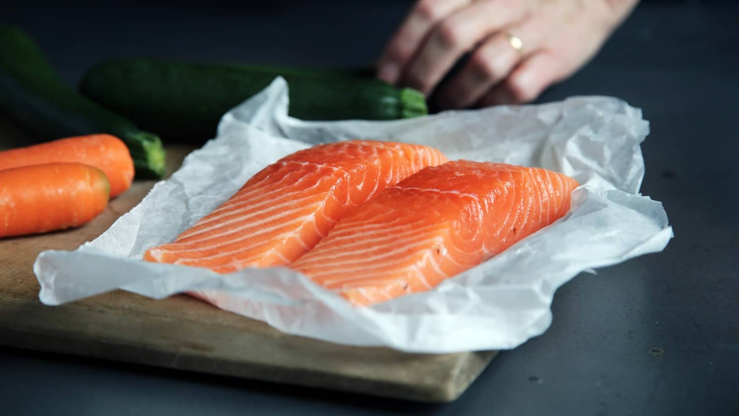 Parchment paper with two pieces of salmon
