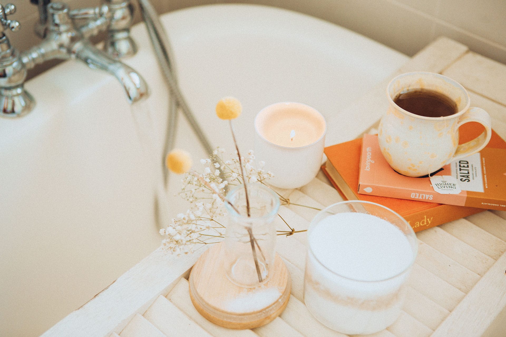 calming items on a tray over a bathtub for self care