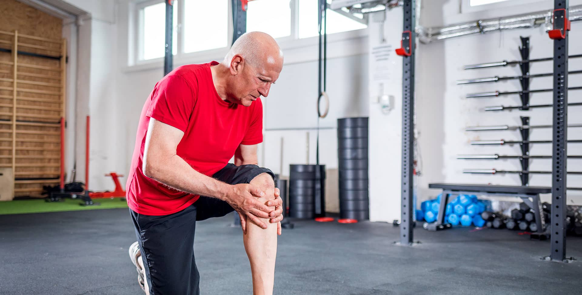 older man with knee pain in gym trying to keep joints healthy