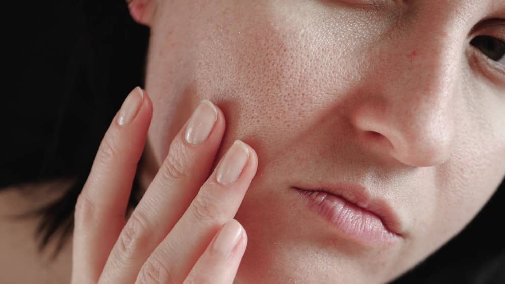 a woman examining her pores to determine her skin type