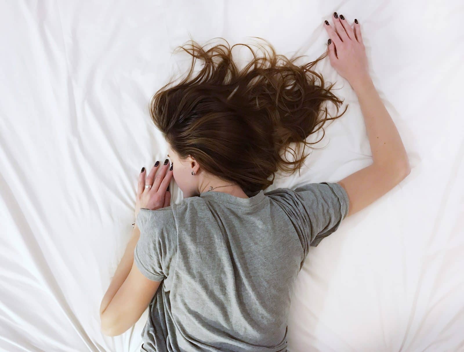 Girl sleeping on stomach across bed