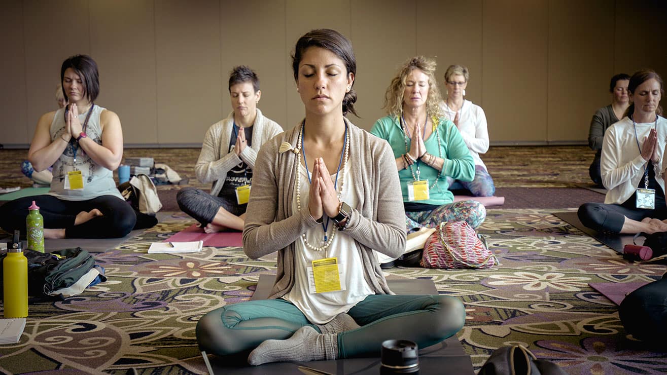 Group of women practicing yoga during a self care retreat