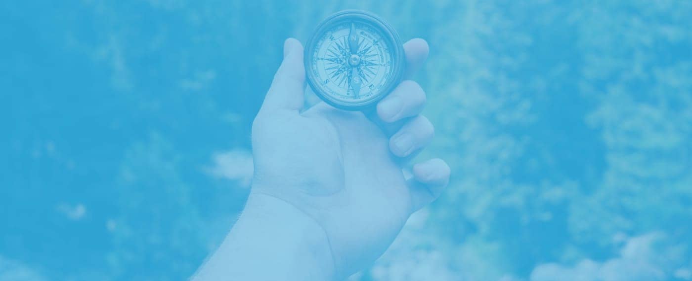 A hand holding a compass